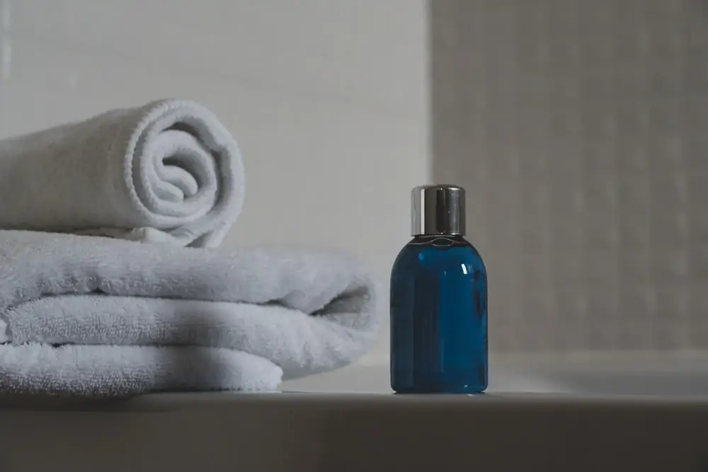 Serviette roulée et flacon dans une salle de bain