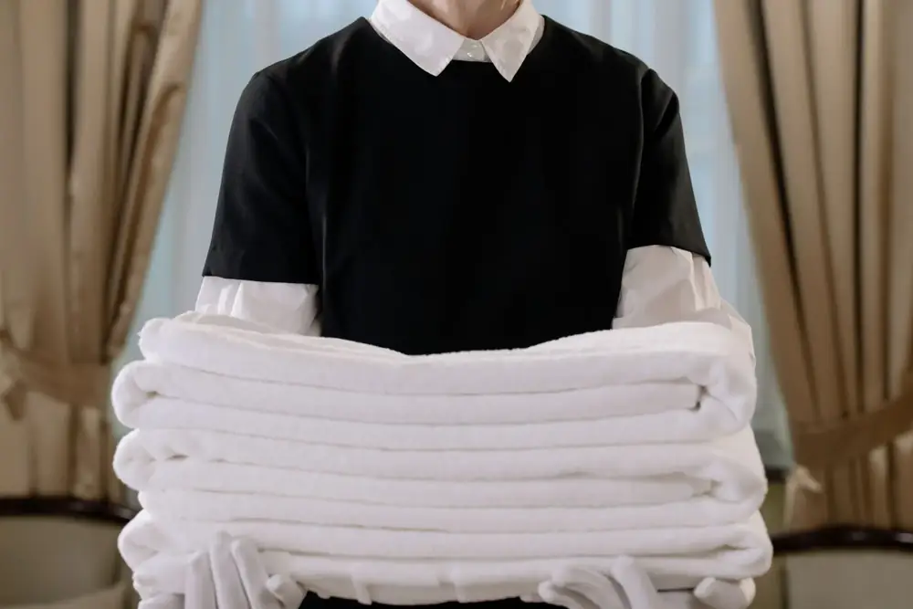 Gouvernante tenant une pile de serviettes blanches